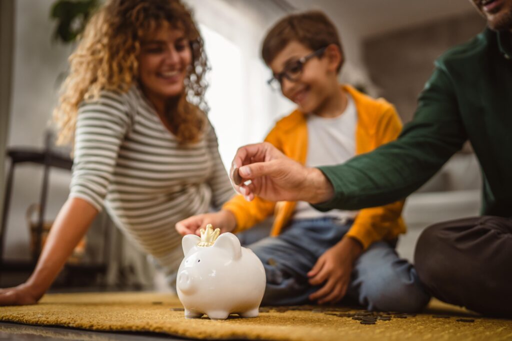 Parents and child saving for education, depositing money into a royal piggy bank, symbolizing financial planning for best education savings plan.